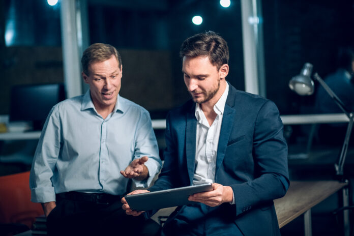 Two busienessmen working late in office.